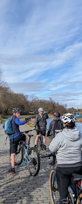 Students on bikes by river Students on bikes by river